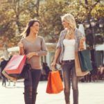 Two beautiful women walking down the street after shopping