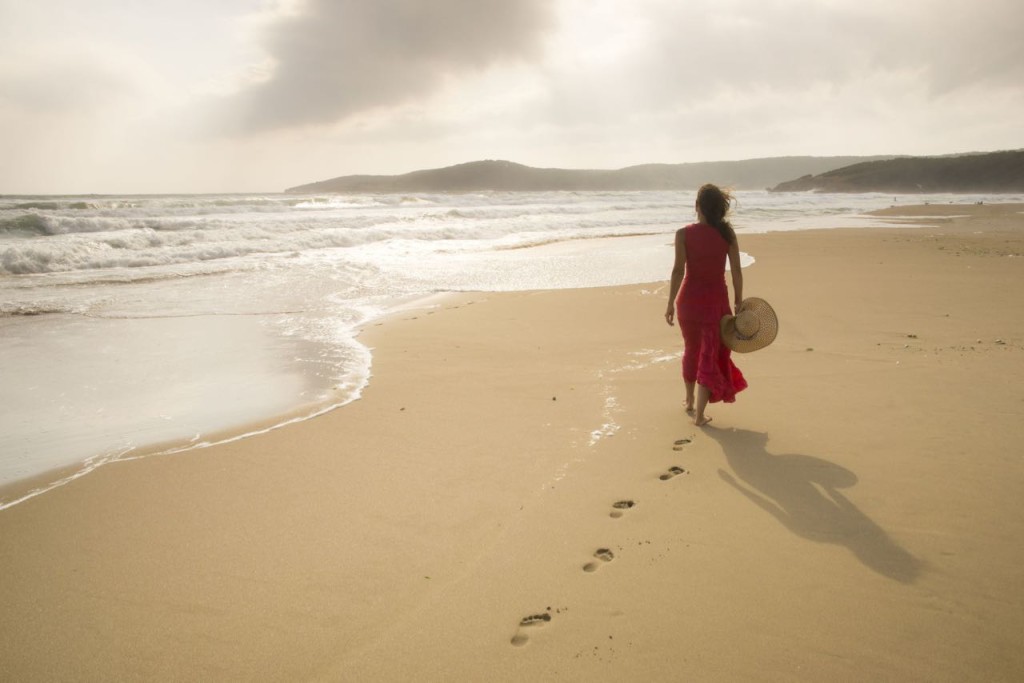 -woman-in-red-walking-on-beach-